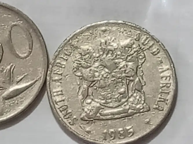 50 cent coin with coat of arms on a light background.