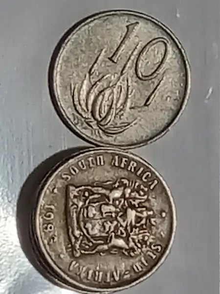 Two 1983 10 cent coins  obverse + reverse
 on a reflective surface