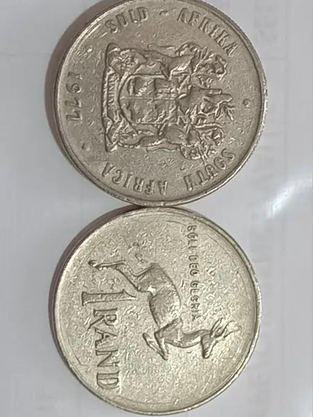 Two R1 coins mint year 1977 with embossed COAT OF ARMOR + SPRINGBOK designs on a white background