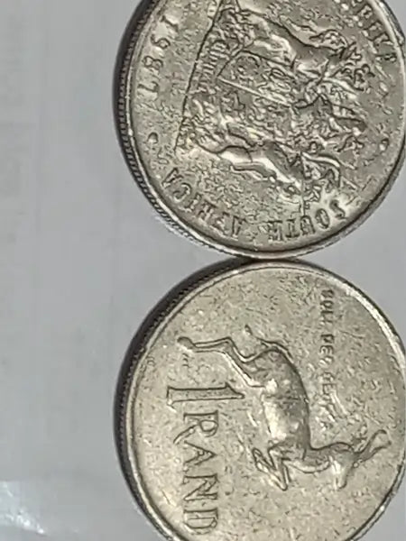 Two 1987 R1  coins with Obverse: Coat of arms of South Africa
Reverse: Springbok, on a light gray background