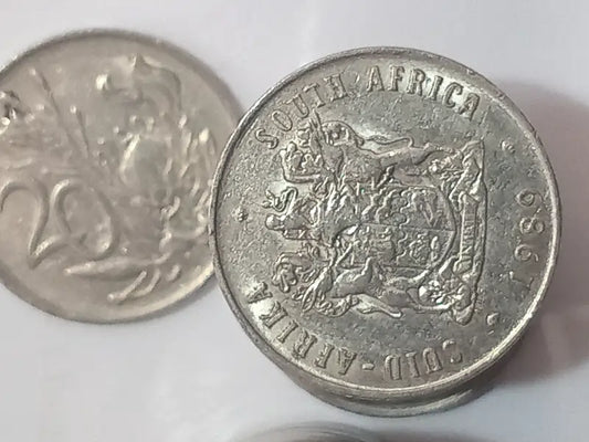 Two 20 cent coins. 
Obverse: Coat of arms of South Africa
Reverse: Protea flower on a white background
