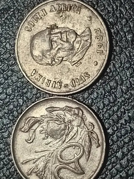 Two  1982 20 cent coins from South Africa on a textured surface