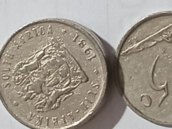 Two 1981 5 cent coins from South Africa on a light gray background