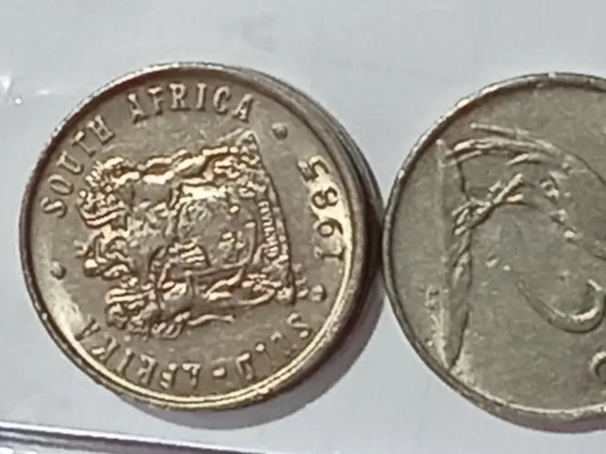 Two 1985 5 cent coins on grey background