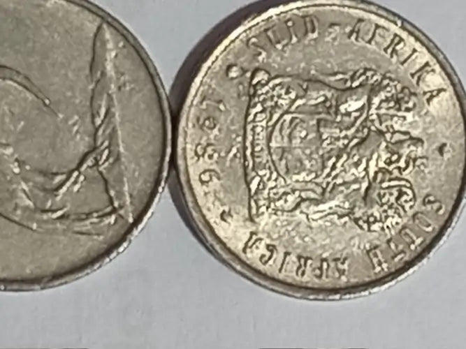 Two 1986  5 cent coins with embossed designs on a gray background