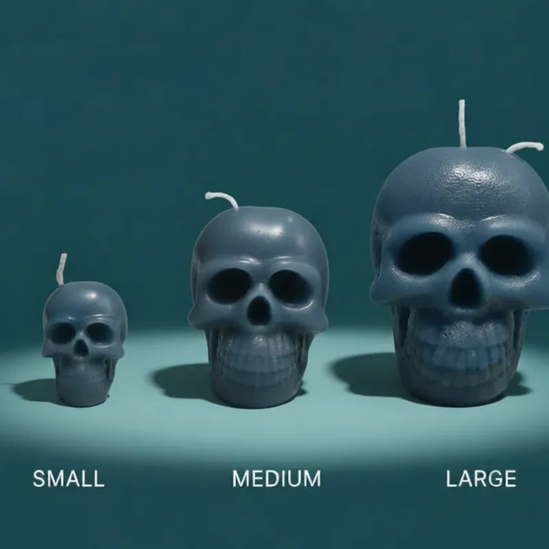 Three skull-shaped candles of different sizes on a teal background