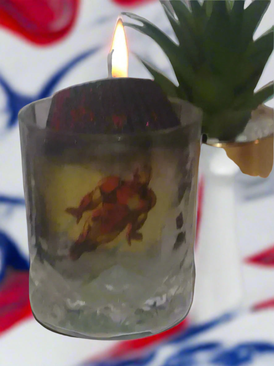 Clear glass with a superhero design on a white surface with a plant in the background