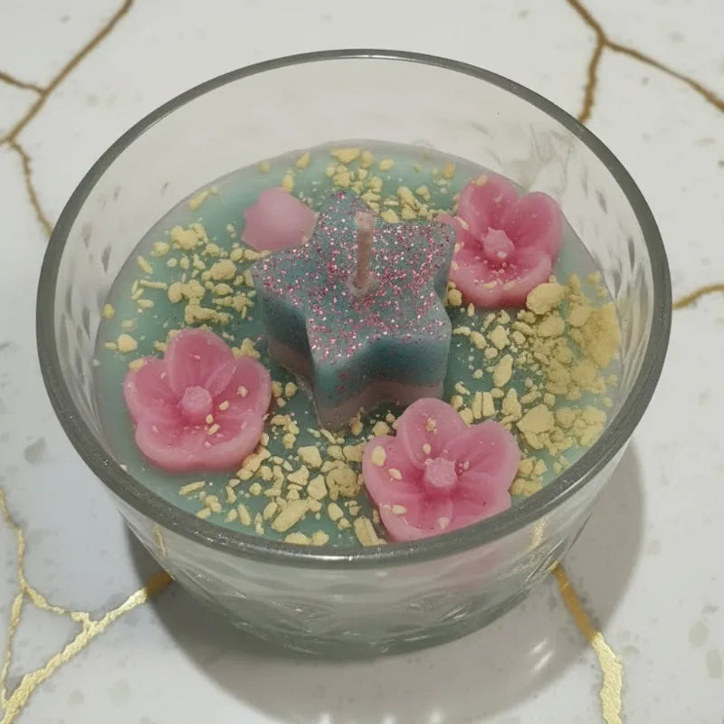 White and Blue bling star-shapes on  candle wick,  in Minnie Mouse glass. Accompanied by Pink flower swirls and yellow wax grains