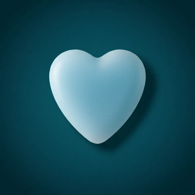 Blue heart-shaped wax candle on dark teal background – LAVA Heart Candle