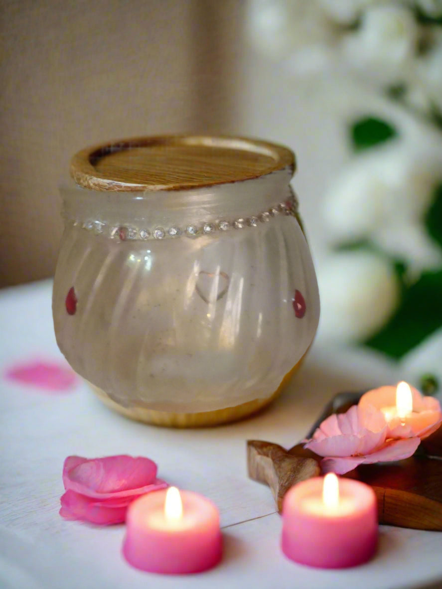 Decorative lantern with pink candles and flowers on a table