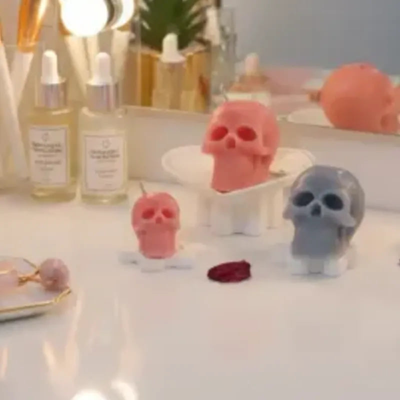 Skull-shaped candles on a table with skincare products in the background