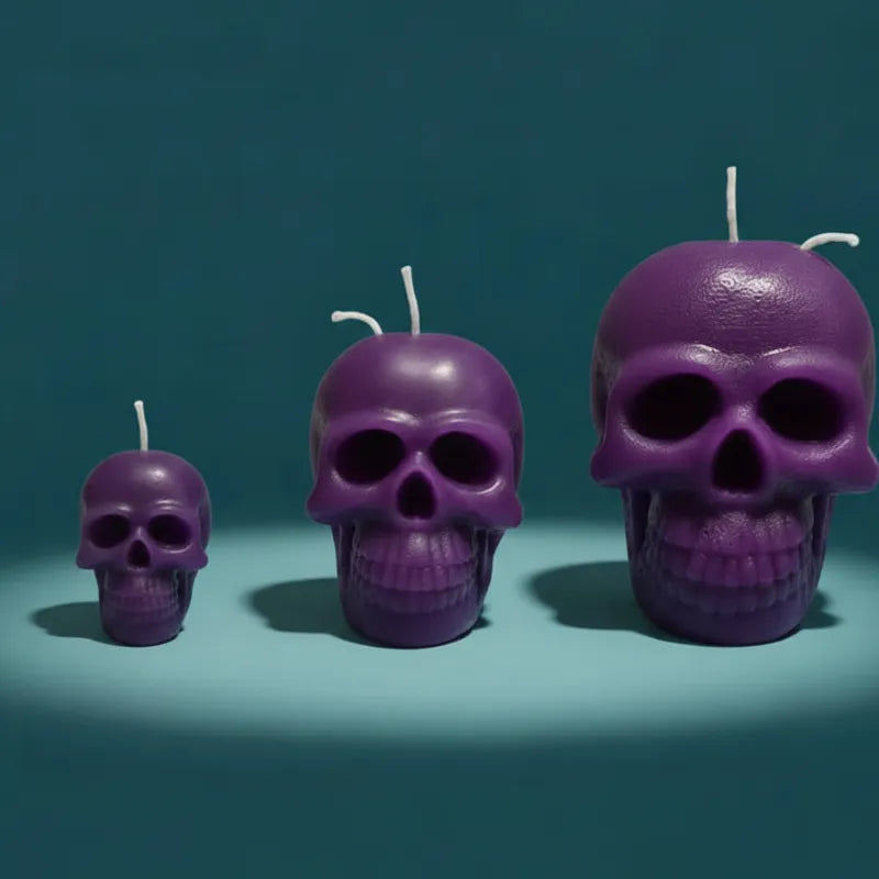 Three purple skull-shaped candles on a teal background