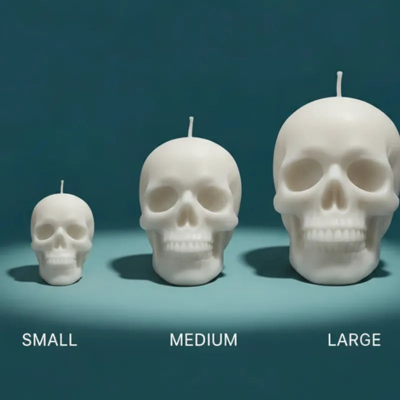 Three skull-shaped candles of different sizes on a teal background