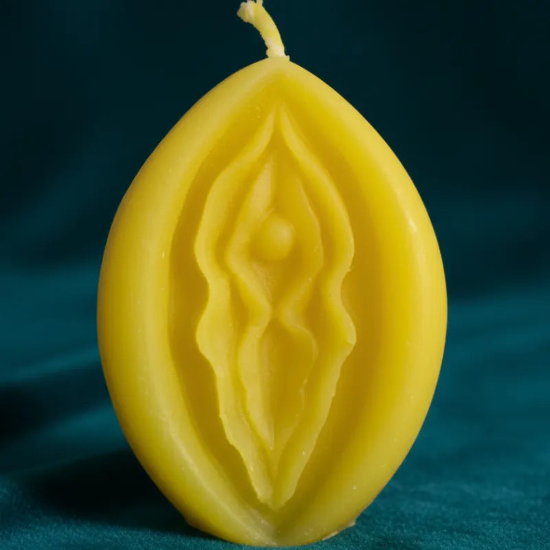 YELLOW V-SPOT candle with intricate designs on a dark background